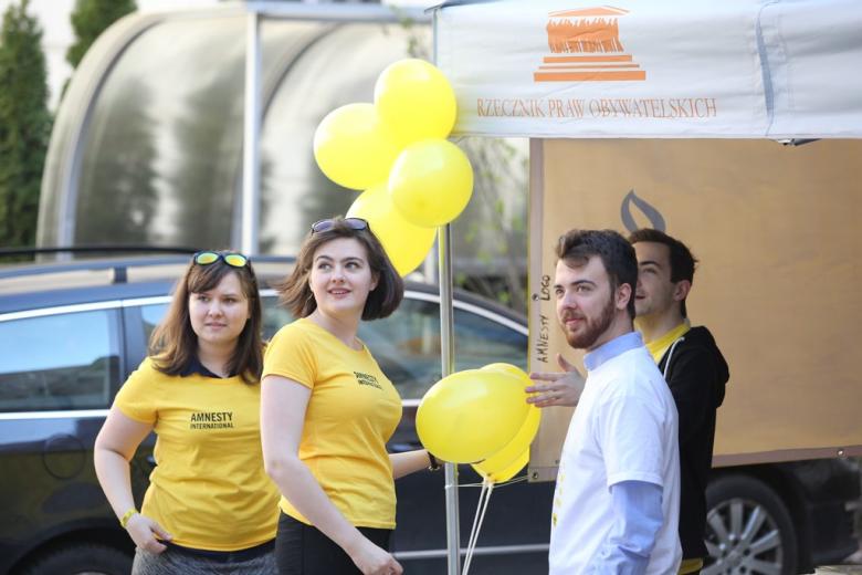 zdjęcie: kilkoro młodych ludzi w żółtych koszulkach stoi pod namiorem Rzecznika Praw Obywatelskich