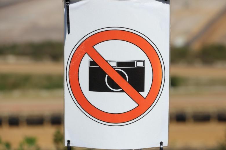 stylizowany znak zakazu z przekreślonym czerwoną barwą aparatem fotograficznym  