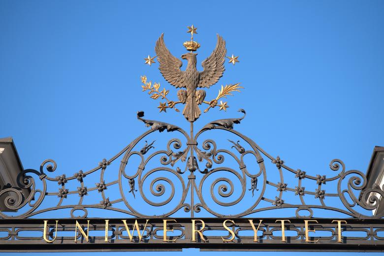 Żelazne okucie bramy uniwersytetu z napisem "Uniwersytet", nad którym znajduje się metaloplastyczna rzeźba orła w koronie