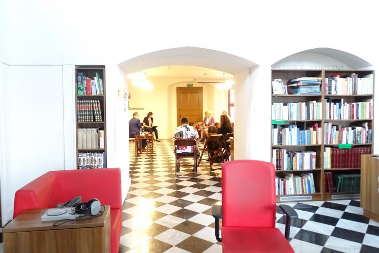 Zdjęcie: zabytkowe wnętrze-biblioteka, ludzie rozmawiają z RPO