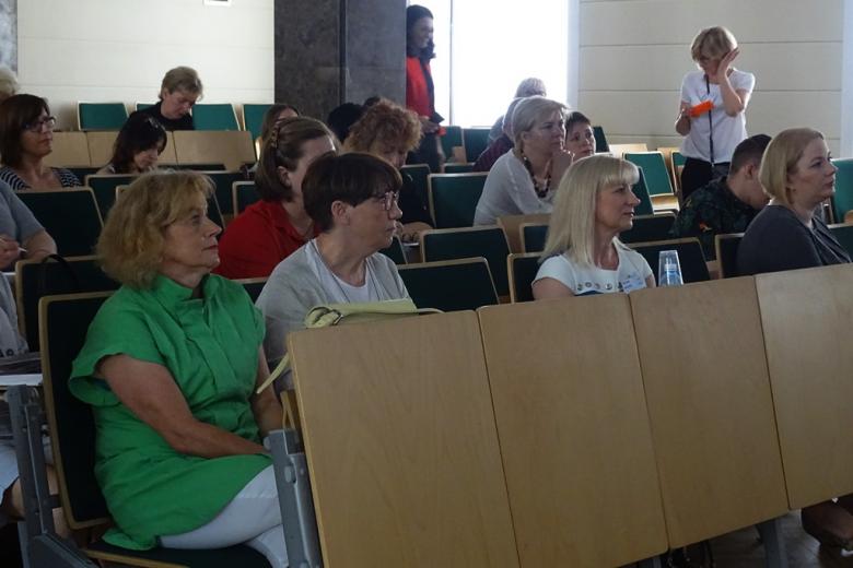 zdjęcie: kilka osób siedzi na auli wykładowej