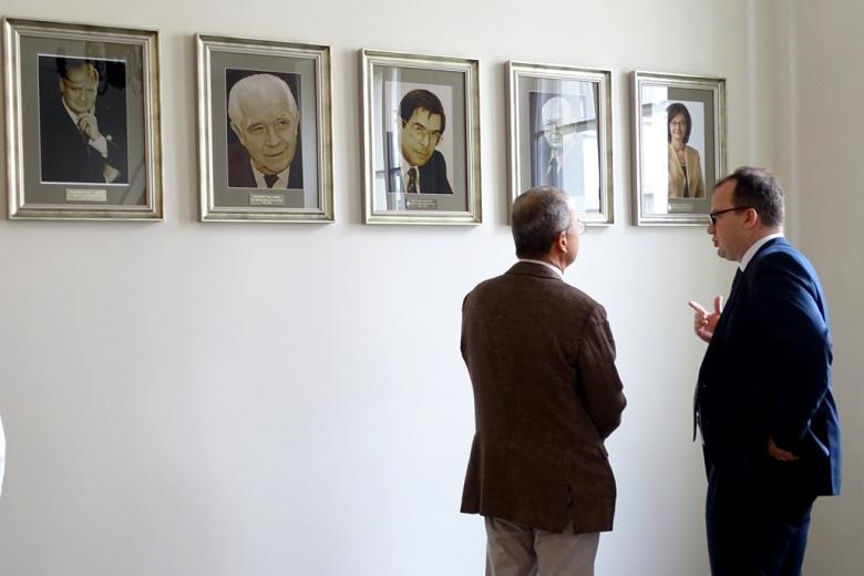 zdjęcie: dwóch mężczyn ogląda portrety wiszące na ścianie