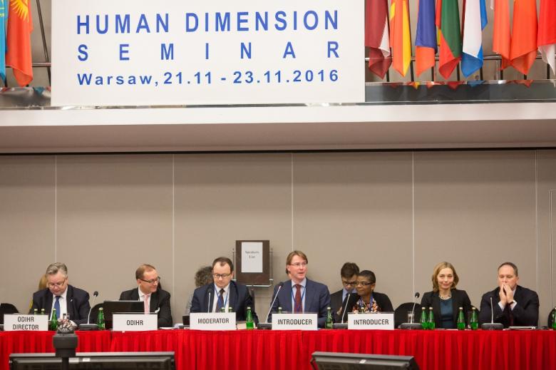 zdjęcie: klika osób siedzi na stołem, u góry widać napis: Human Dimension Seminar
