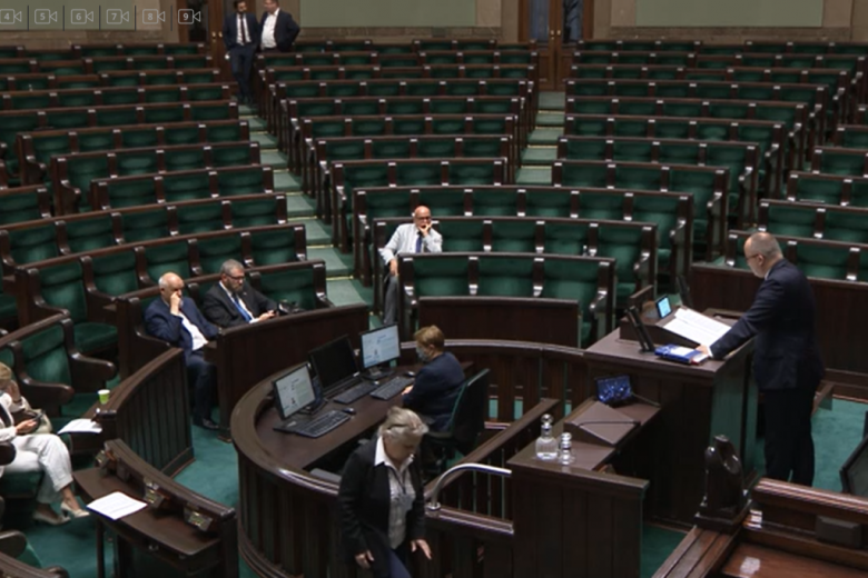 Mężczyzna na mówinicy w Sejmie. Puste ławy po prawej stronie