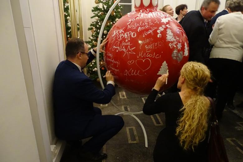 Zdjęcie: ludzie malują wielką świąteczną bombkę