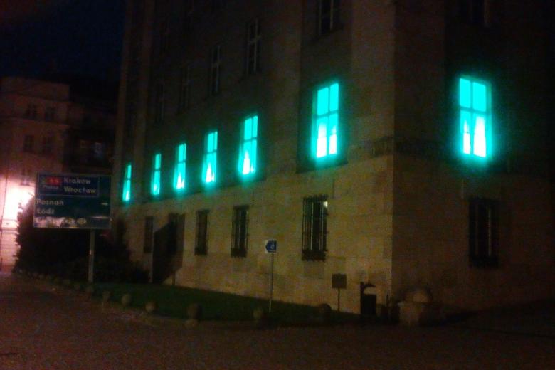 zdjęcie: budynek w którym okna na pierwszym piętrze podświetlone są na zielono