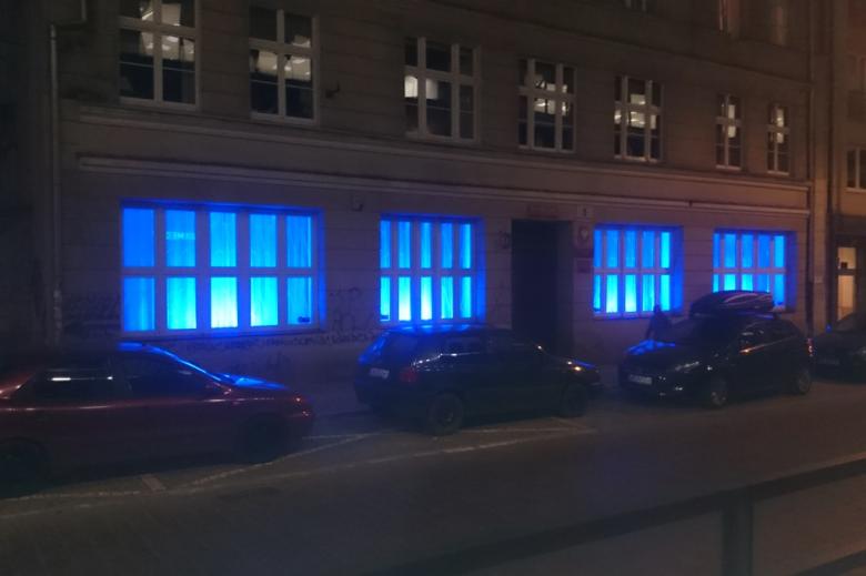 zdjęcie: kamienica z oknami na parterze podświetlonymi na niebiesko
