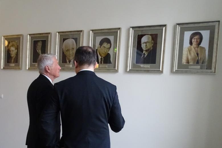 Zdjęcie: dwóch mężczyzn ogląda portrety na ścianie
