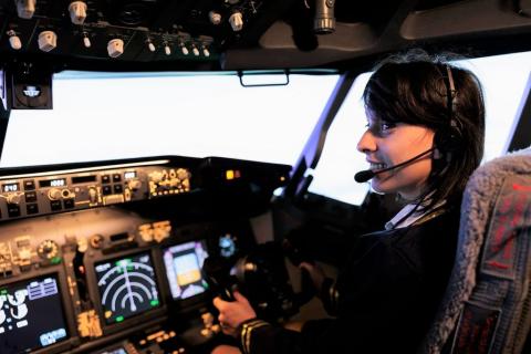 kobieta - pilotka siedzi za sterami w kabinie samolotu 