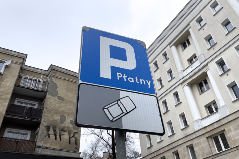 znak  parkingu w mieście z dopiskiem płatny 
