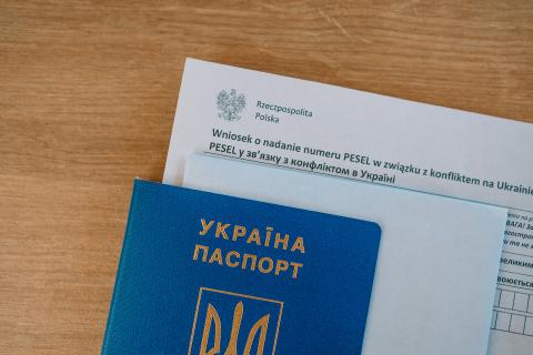 Formularz urzędowy z wnioskiem o nadanie numeru PESEL w związku z konfliktem na Ukrainie włożony w ukraiński paszport