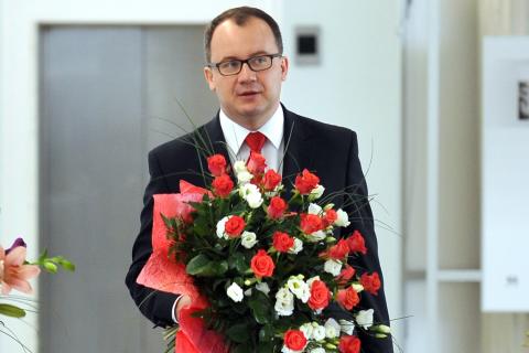 Zdjęcie: Adam Bodnar z wielkim bukietem biało-czerwonych kwiatów